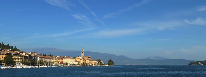 Trip Schottland beliebte Urlaubsziele am Gardasee -  Mit einer Fläche von 370 km² ist der Gardasee der größte See Italiens. Es liegt am Fuße der Alpen und erstreckt sich über drei Staaten: Lombardei, Venetien und Trentino. Die maximale Tiefe des Sees beträgt 346 m, er hat eine längliche Form und sein nördliches Ende ist sehr schmal. Dort ist der See von den Bergen der Gruppo di Baldo umgeben. Du trittst aus deinem gemütlichen Hotelzimmer und es begrüßt dich die warme italienische Sonne. Du blickst auf den atemberaubenden Gardasee, der in zahlreichen Blautönen schimmert - von tiefem Dunkelblau bis zu funkelndem Türkis. Majestätische Berge umgeben dich, während die Brise sanft deine Haut streichelt und der Duft von blühenden Zitronenbäumen deine Nase kitzelt. Du schlenderst die malerischen, engen Gassen entlang, vorbei an farbenfrohen, blumengeschmückten Häusern. Vereinzelt unterbricht das fröhliche Lachen der Einheimischen die friedvolle Stille. Du fühlst dich wie in einem Traum, der nicht enden will. Jeder Schritt führt dich zu neuen Entdeckungen und Abenteuern. Du probierst die köstliche italienische Küche mit ihren frischen Zutaten und verführerischen Aromen. Die Sonne geht langsam unter und taucht den Himmel in ein leuchtendes Orange-rot - ein spektakulärer Anblick.
